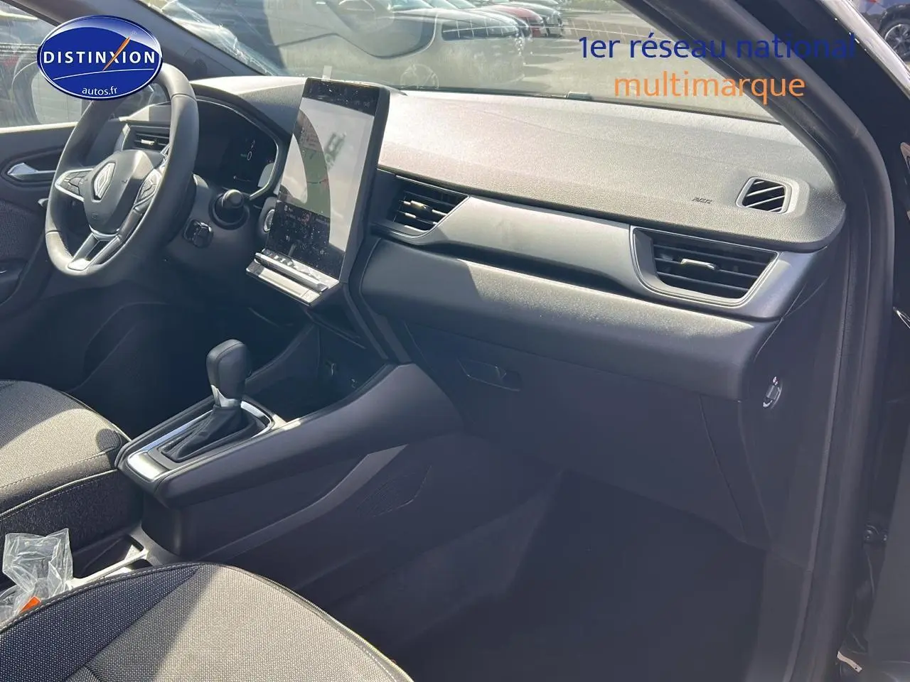 Vue intérieure côté passager du tableau de bord et console centrale du Renault Captur 1.6 e-tech hybride noir étoile 2025.