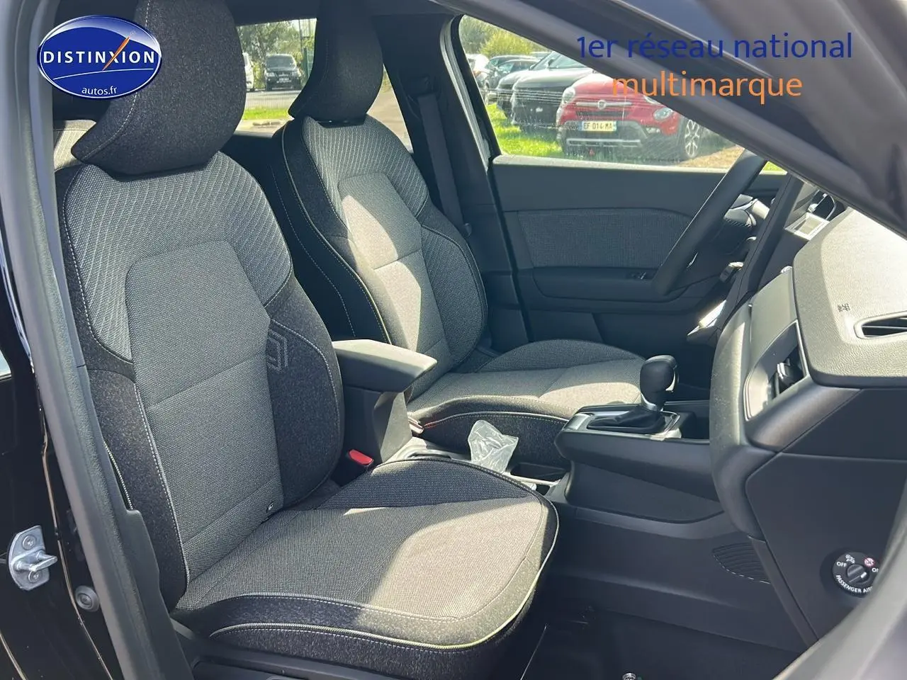 Vue intérieure côté gauche du Renault Captur 1.6 e-tech hybride 2025 avec sièges tissu gris et console centrale noire.