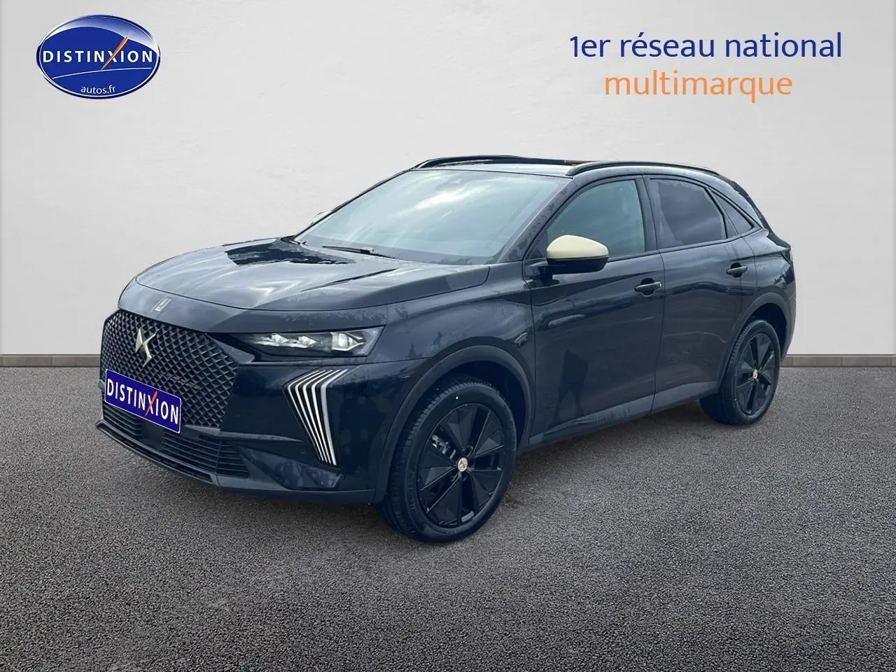 Vue 3/4 avant du DS7 noir avec jantes noires et rétroviseurs couleur crème sur fond neutre.