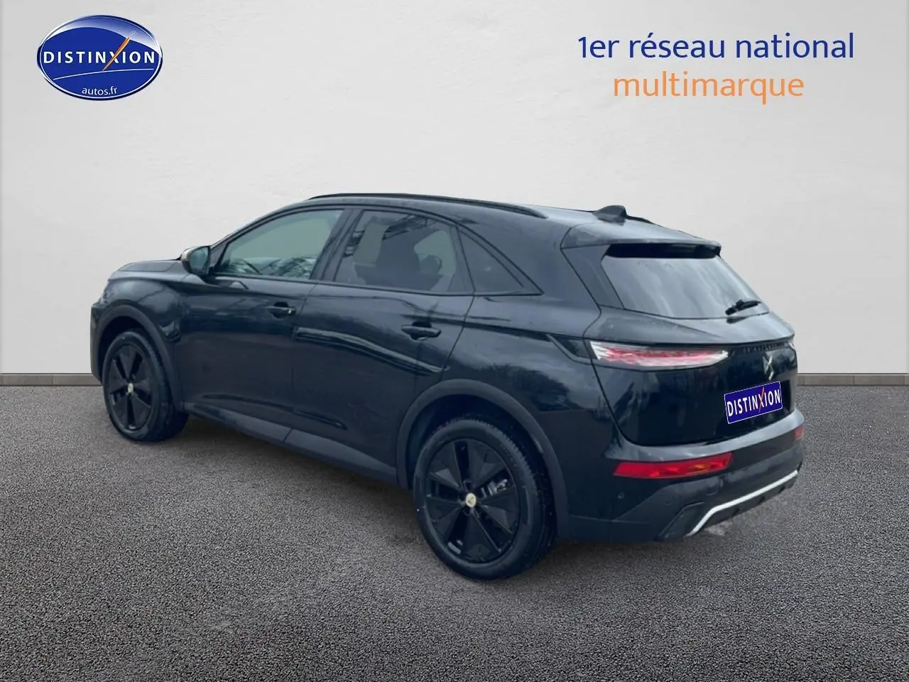 Vue 3/4 arrière droite du SUV DS7 noir brillant avec jantes noires et feux arrière LED allumés.
