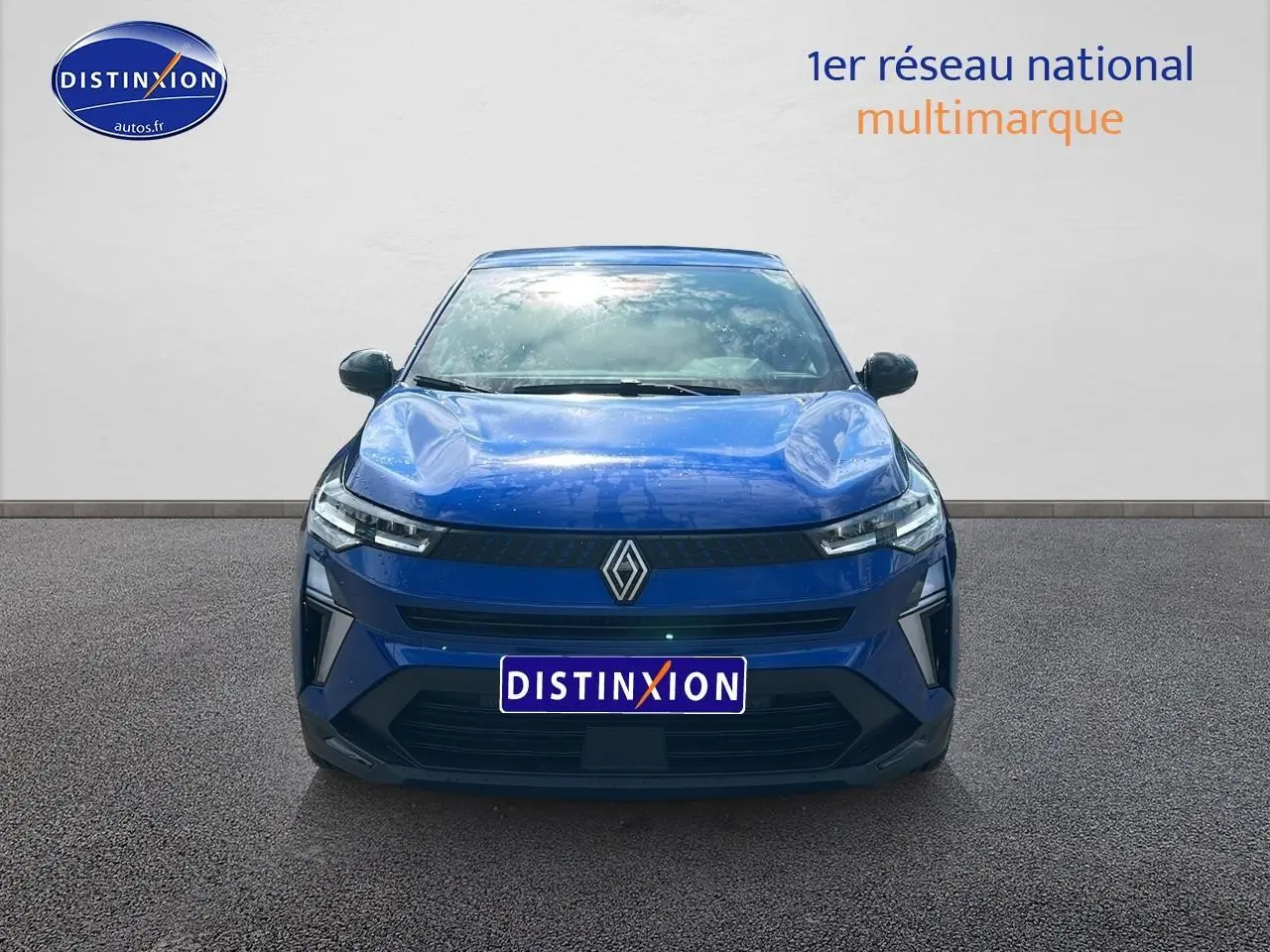 Vue frontale d'un Renault Captur 1.6 e-tech hybride 145 techno en bleu iron avec calandre noire et phares LED fins.