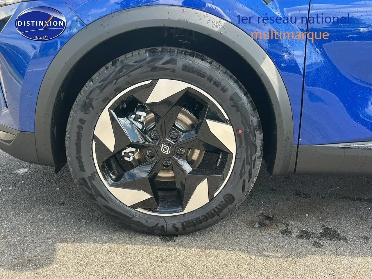 Gros plan sur la roue avant gauche du Renault Captur bleu iron, mettant en valeur la jante alu au design géométrique.