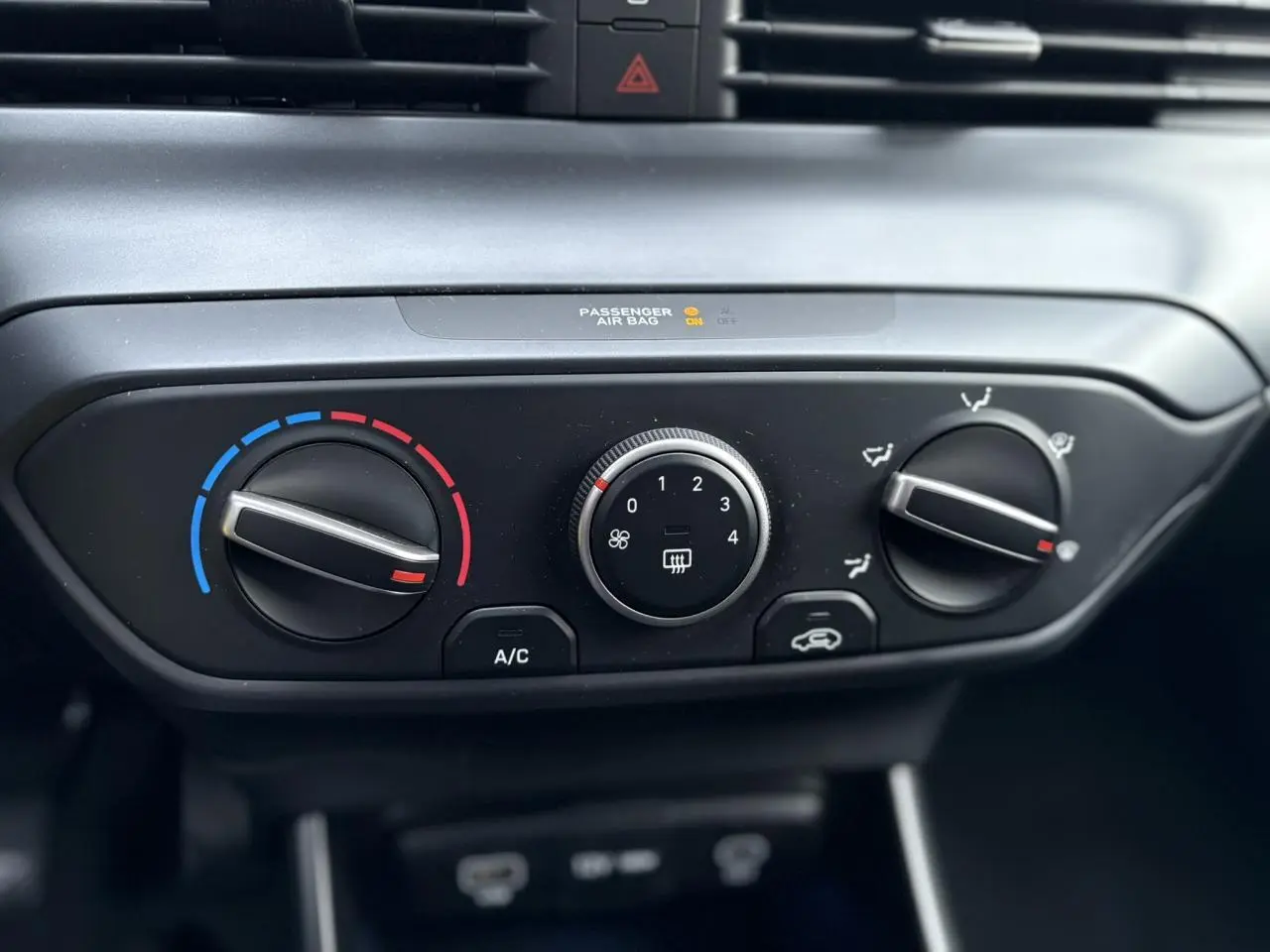 Gros plan sur les commandes de climatisation manuelle de la Hyundai i20 2025, avec réglages température, ventilation et air recyclé.
