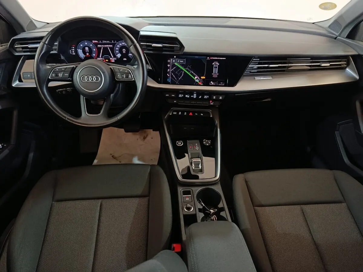 Vue intérieure avant de l'Audi A3 35 TDI noire, avec tableau de bord numérique et écran tactile central.