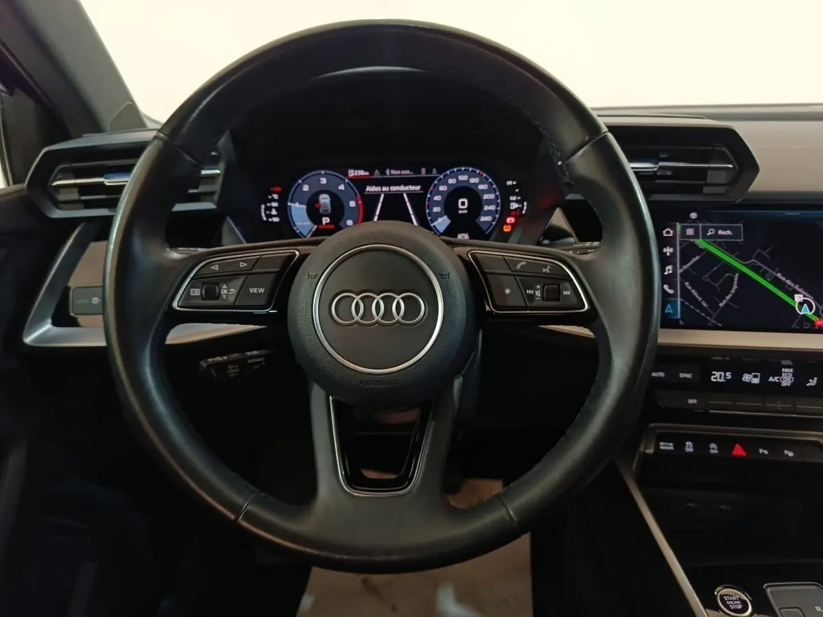 Vue centrée sur le volant cuir noir d’Audi A3 35 TDI 2023 avec tableau de bord digital et écran tactile de navigation.