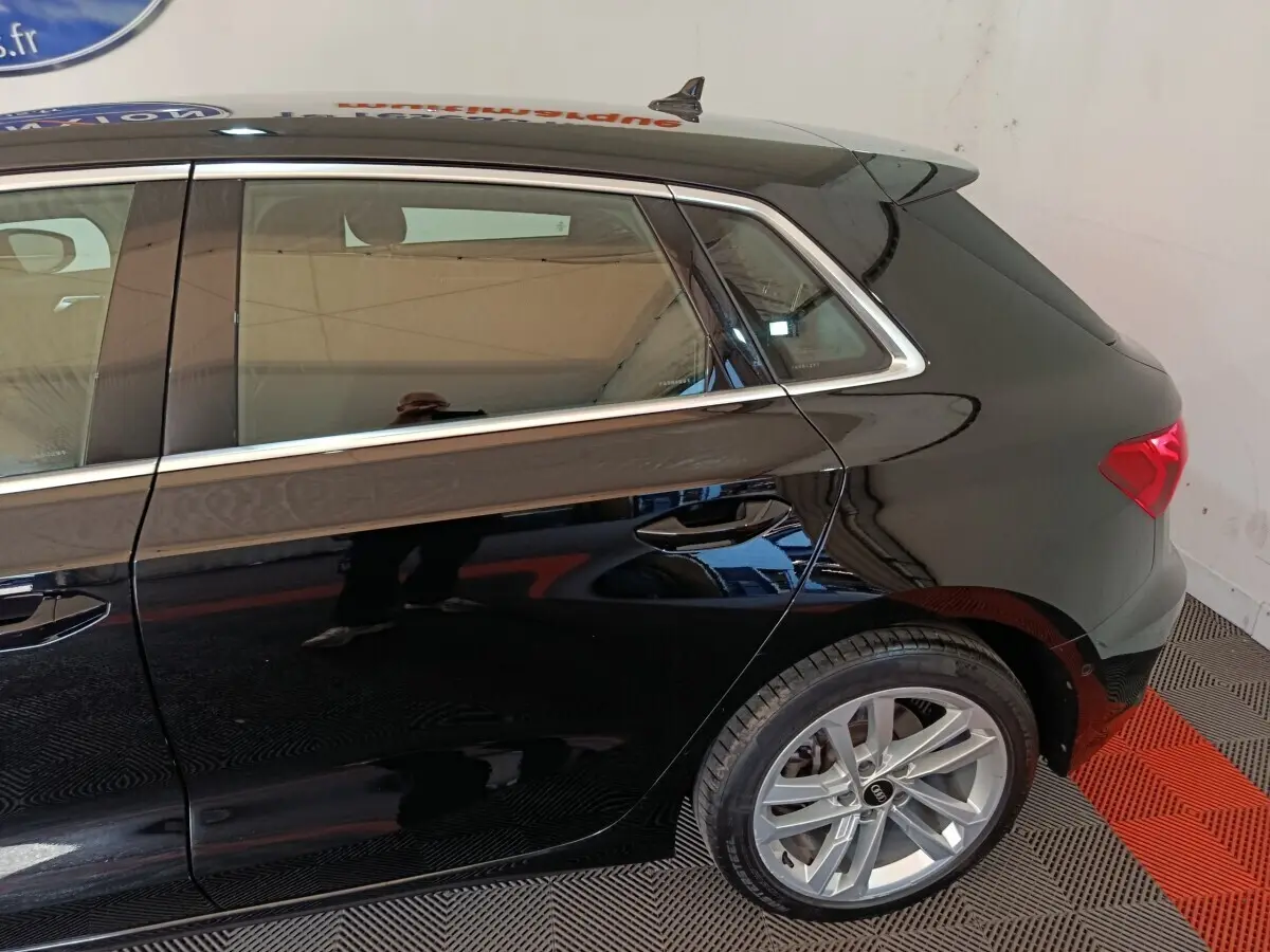 Vue latérale arrière droite d'une Audi A3 noire 2023 avec jantes alliage et feux arrière LED visibles.