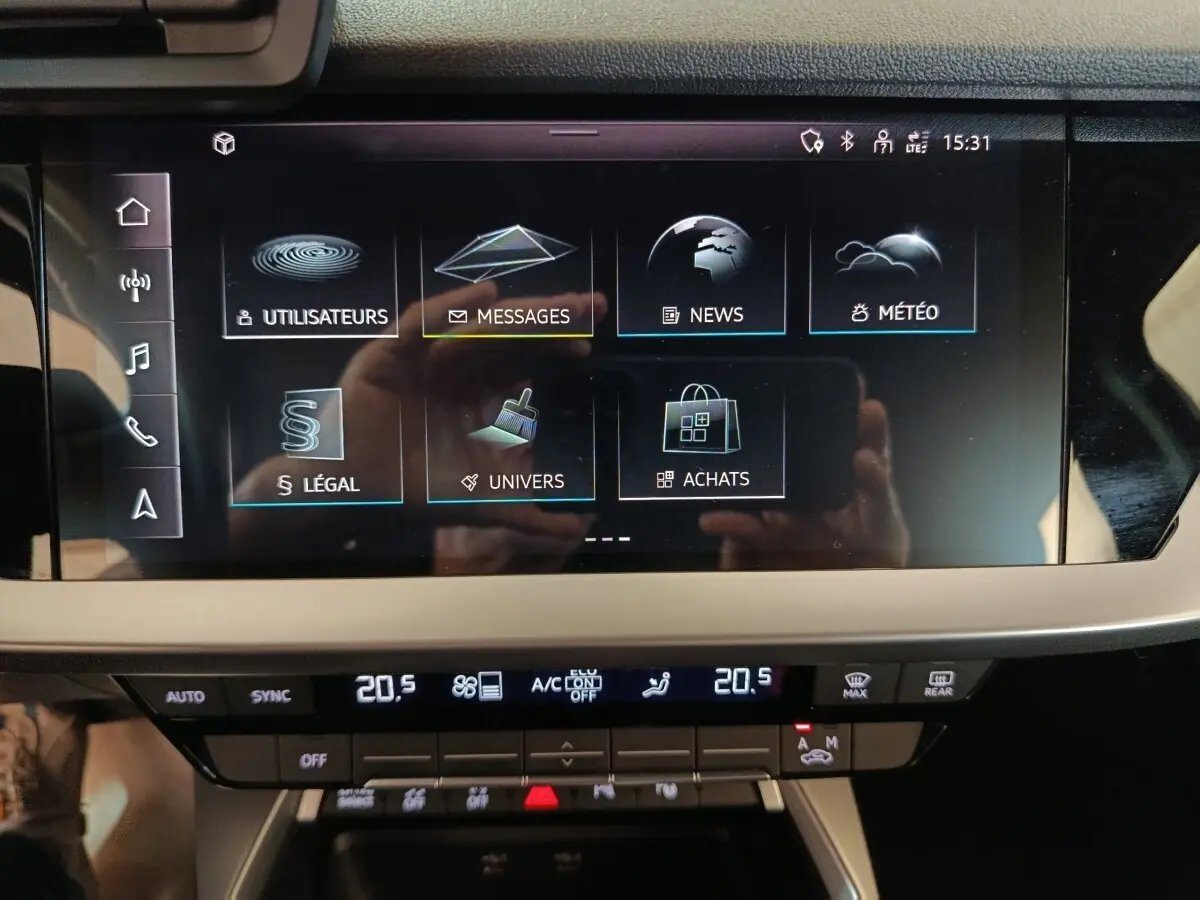 Écran tactile central de l'Audi A3 35 TDI noir, affichant le menu multimédia avec commandes climatisation en dessous.
