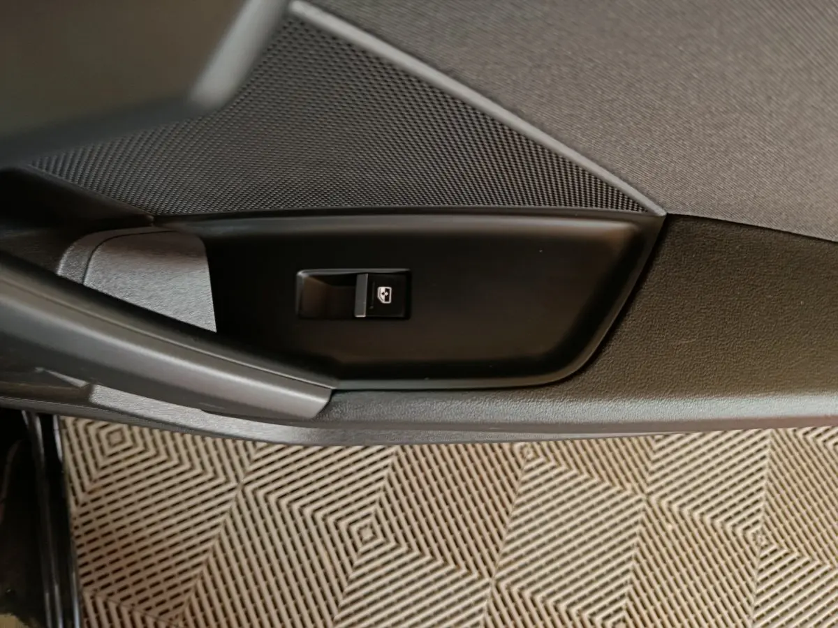 Gros plan sur le bouton de verrouillage des portes côté gauche de la porte intérieure d’une Audi A3 noire 2023.