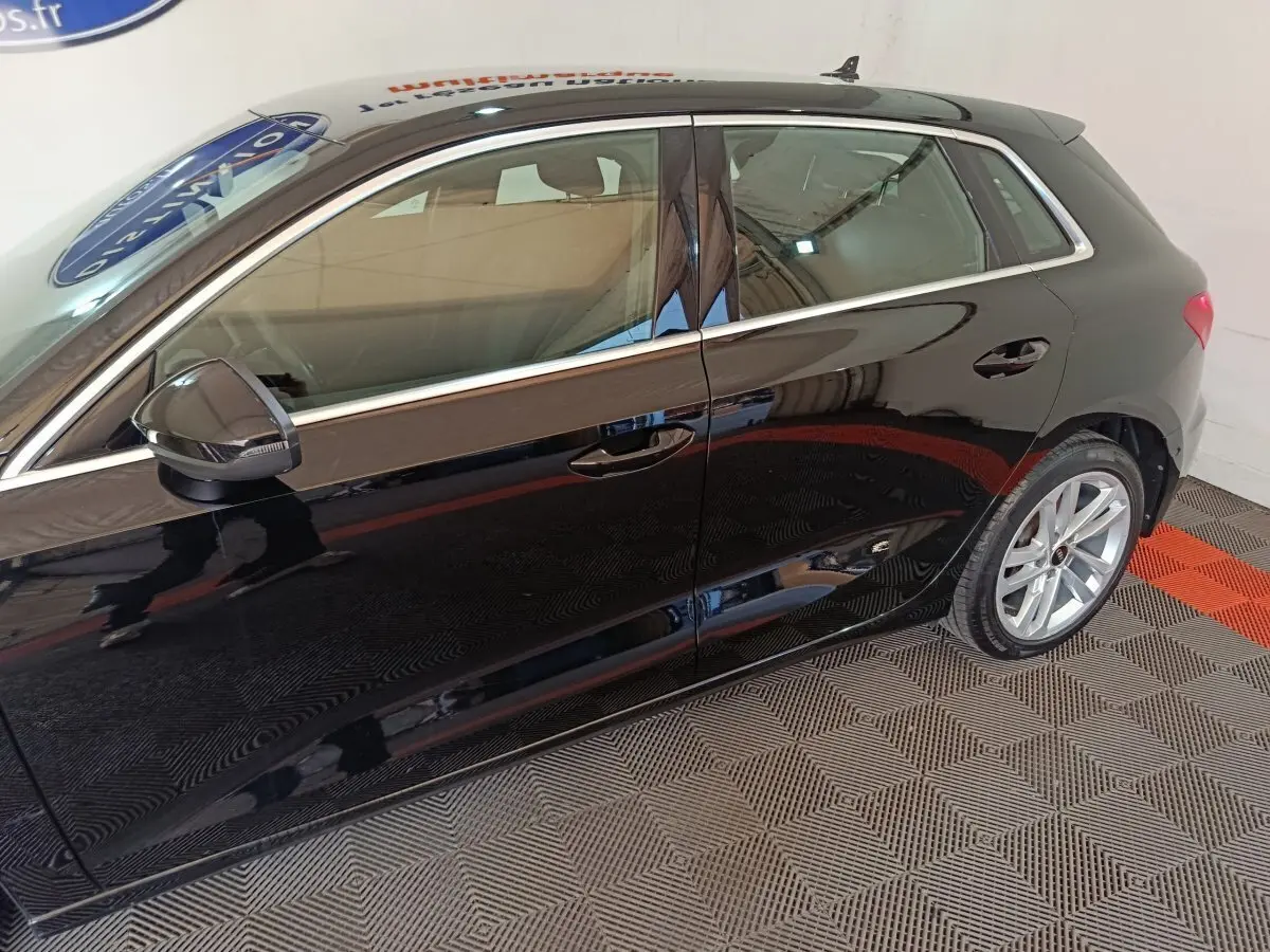 Vue latérale gauche d'une Audi A3 noire 2023 avec jantes alliage et rétroviseur noir brillant.