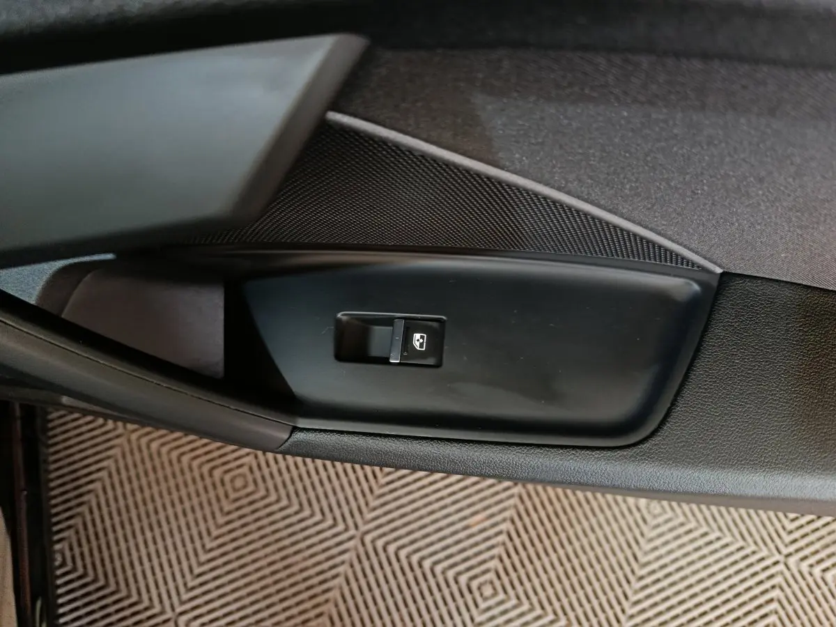 Bouton de commande de vitre électrique sur la porte intérieure noire d'une Audi A3 35 TDI 2023.