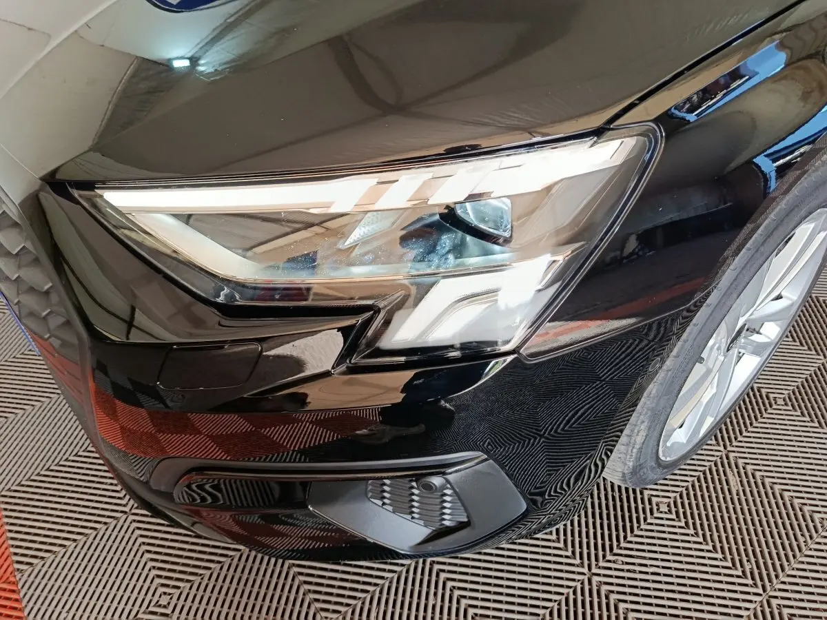 Gros plan sur l'avant droit noir de l'Audi A3 35 TDI 150 S tronic avec phares LED et calandre distinctive.
