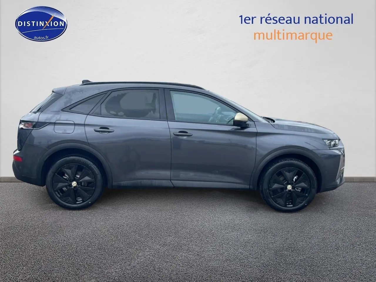 Vue de profil côté gauche d'un DS7 gris titane avec jantes noires et rétroviseurs couleur carrosserie.