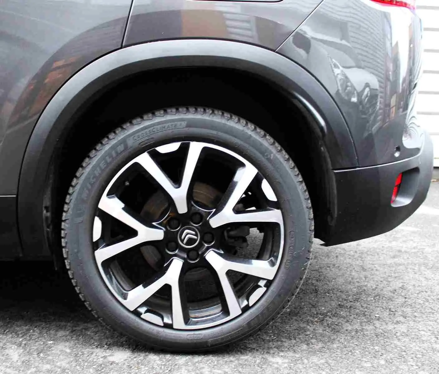 Gros plan sur la roue arrière droite du Citroën C5 Aircross gris platinium, avec jante alliage bicolore distinctive.