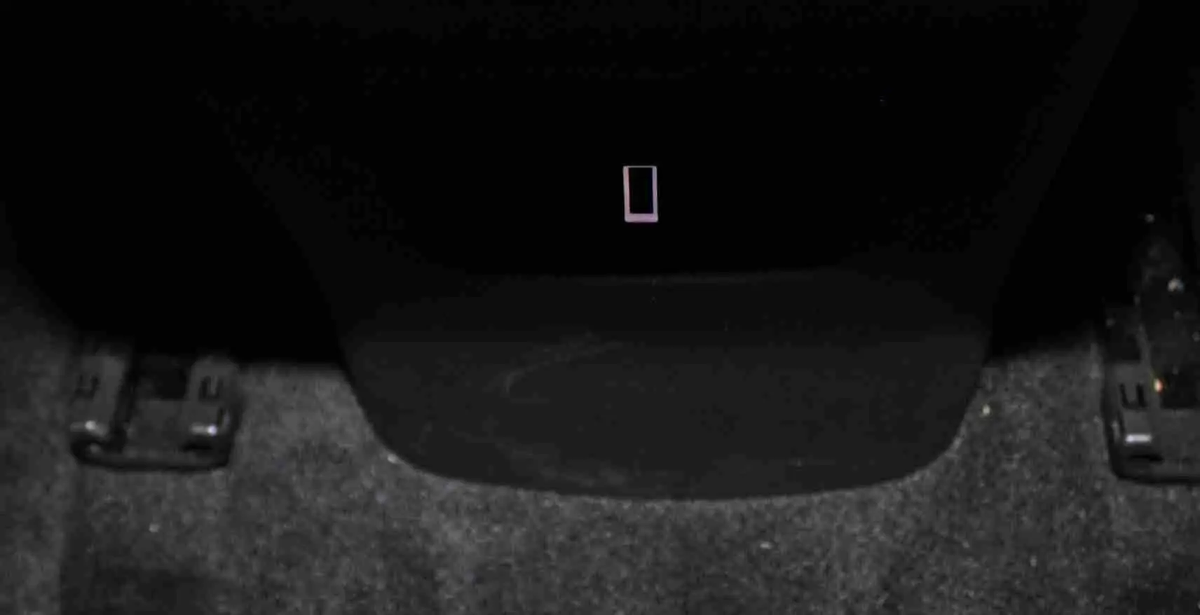 Gros plan sur la console centrale noire et le tapis gris foncé au sol d'un Citroën C5 Aircross hybride rechargeable.