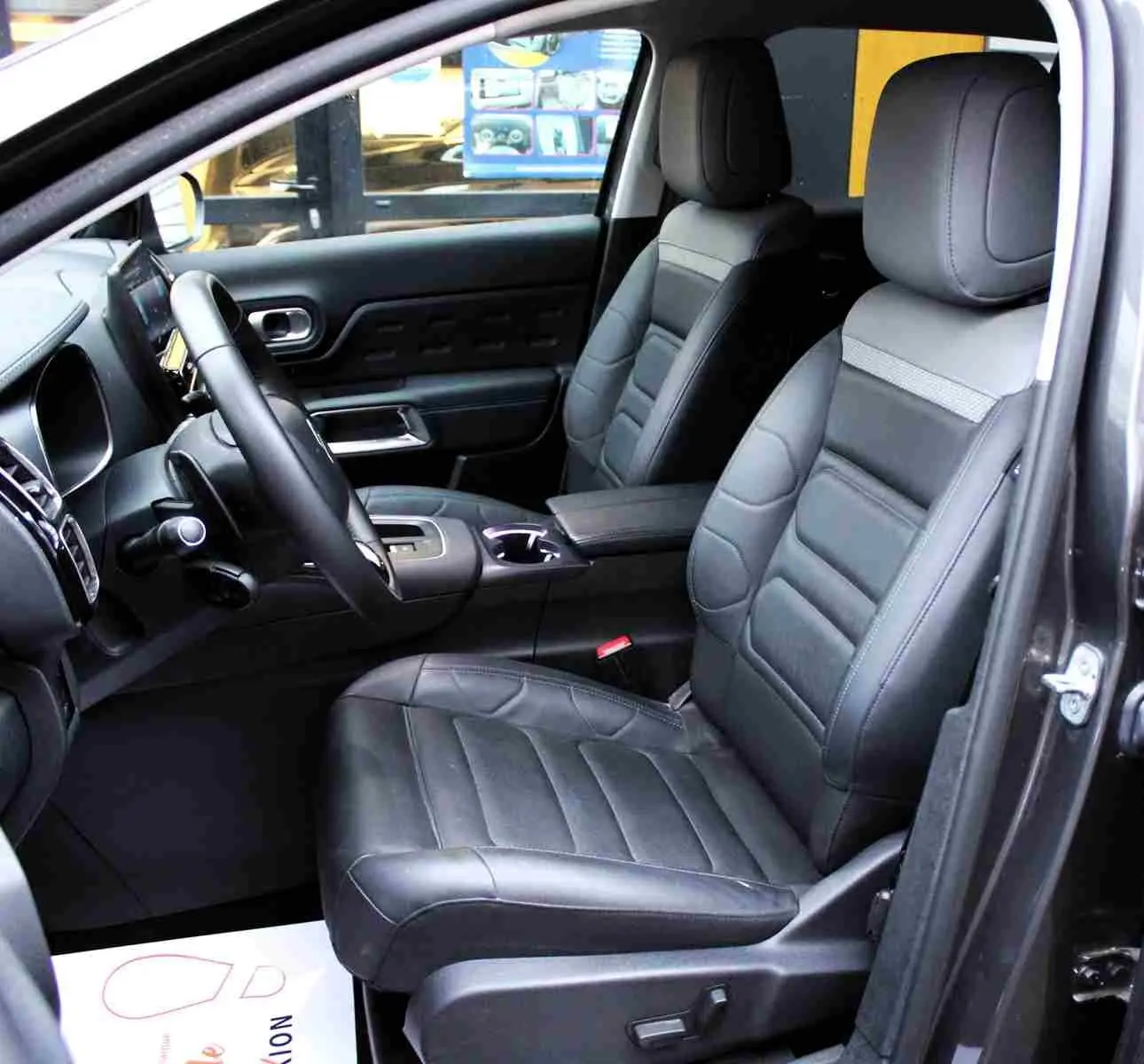 Vue intérieure côté conducteur du Citroën C5 Aircross gris platinium, sièges en cuir noir et tableau de bord moderne.