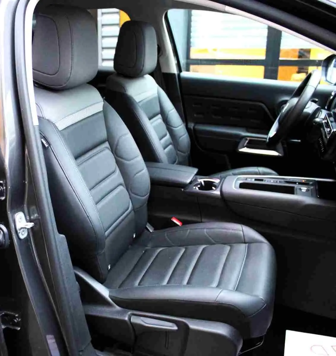 Vue intérieure côté gauche du Citroën C5 Aircross gris platinium, mettant en valeur les sièges avant en cuir noir et la console centrale.