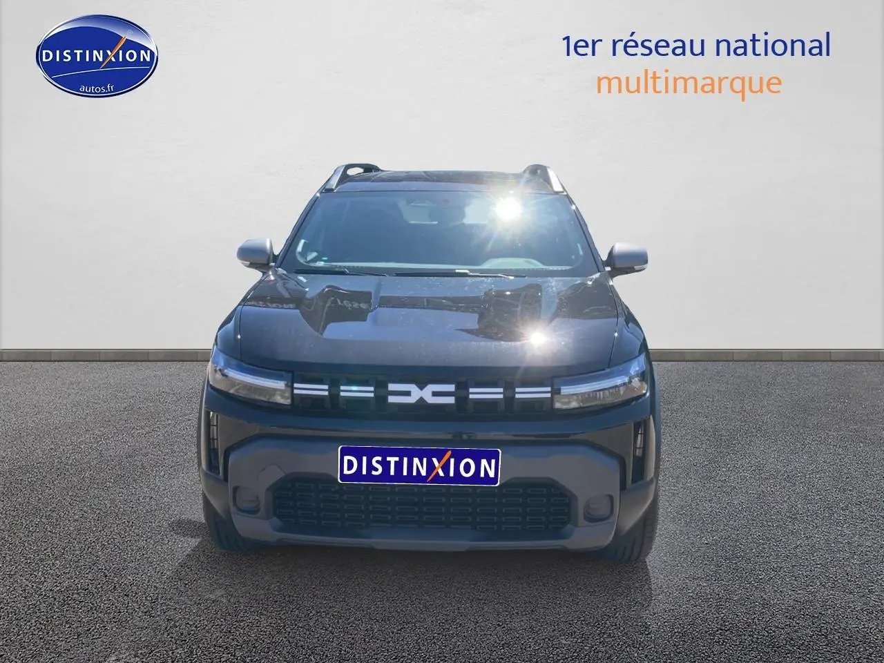 Vue avant d'un Dacia Duster noir 2025 avec calandre moderne et phares LED fins allumés.