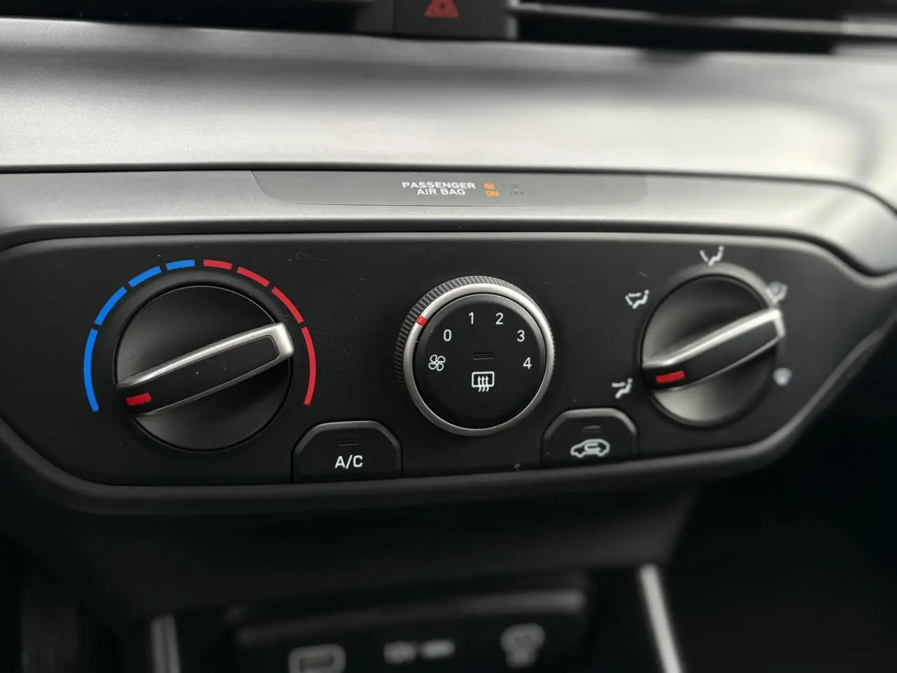 Gros plan sur les commandes de climatisation manuelle de la Hyundai i20 2025 en gris Aurora Metal.