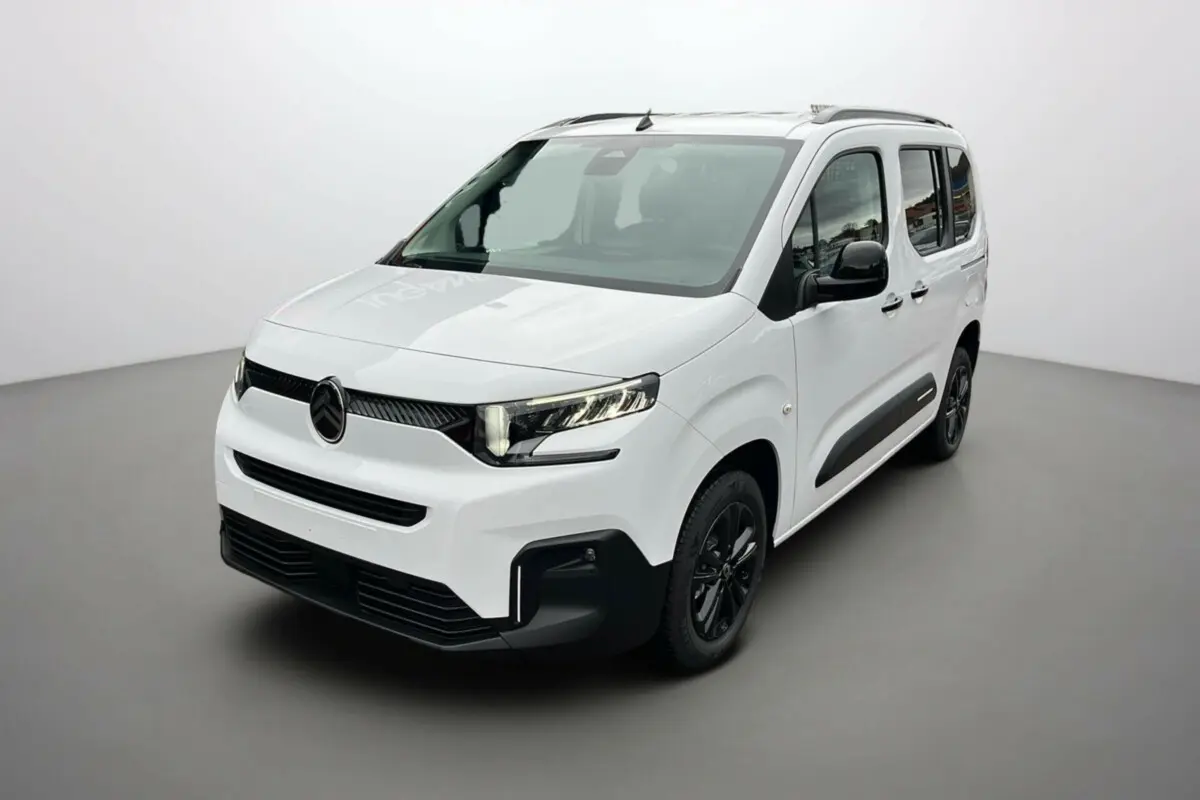 Vue 3/4 avant droite du Citroën Berlingo Kaolin white avec jantes noires et barres de toit visibles.