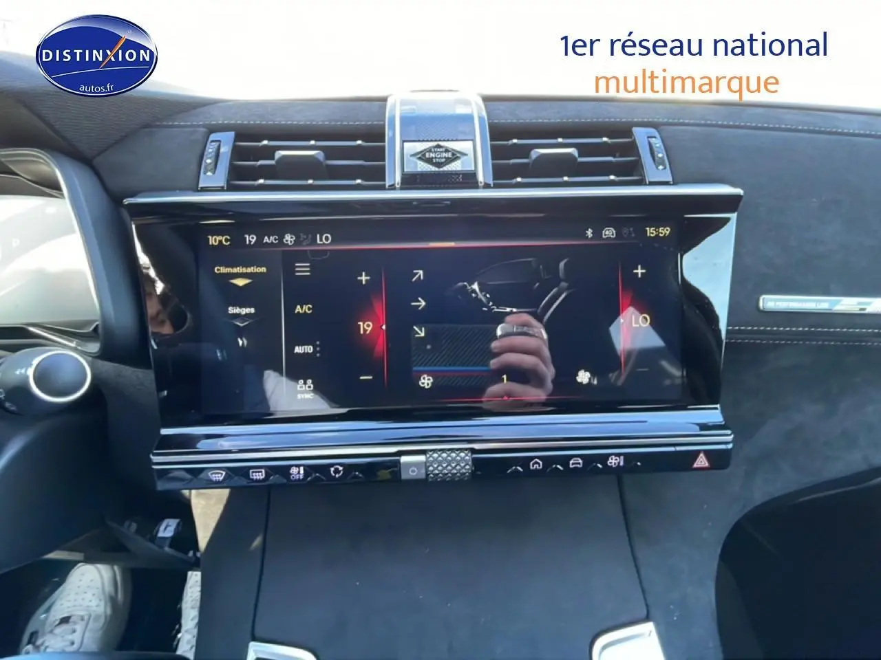 Vue rapprochée de l'écran tactile central noir du tableau de bord du DS7 bleu, avec commandes climatisation visibles.