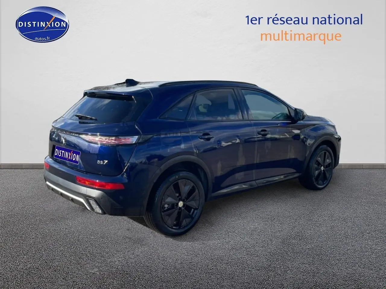 Vue 3/4 arrière droite d’un DS7 bleu foncé avec jantes noires et vitres arrière surteintées.
