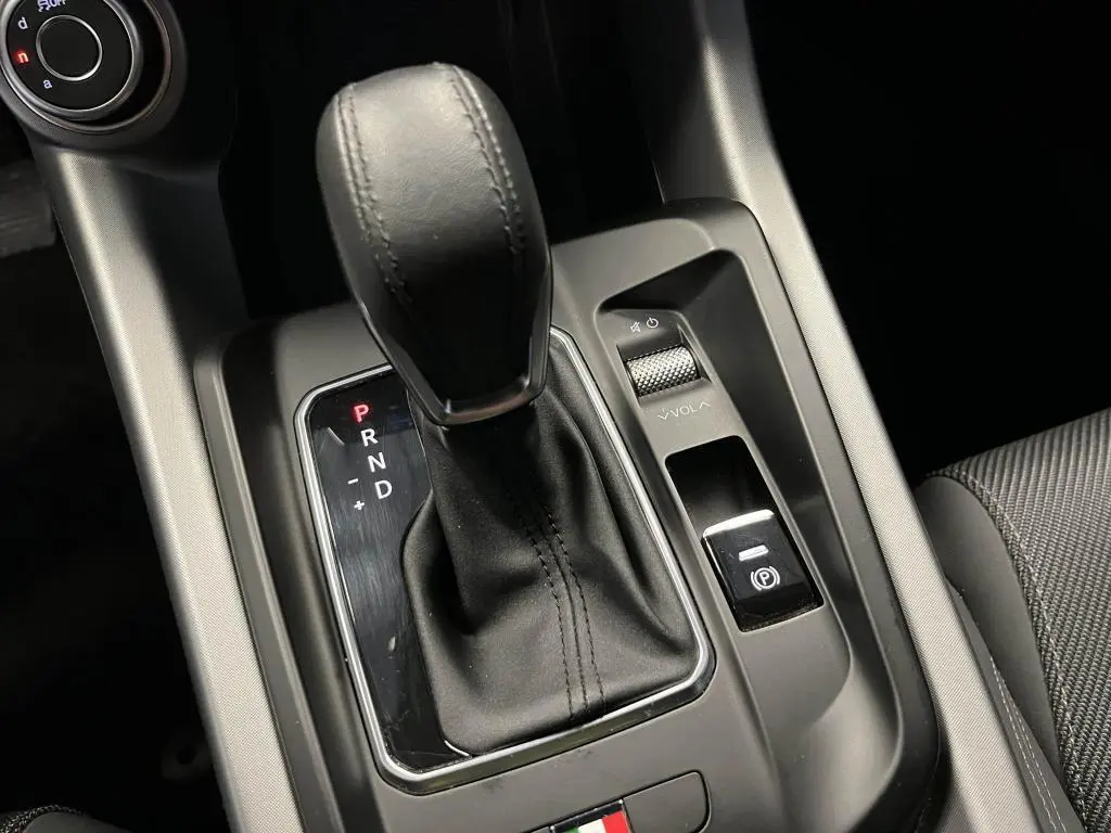 Gros plan sur la commande de boîte automatique et frein électrique de l'Alfa Romeo Tonale 1.5 mHEV 160 TI, intérieur noir.