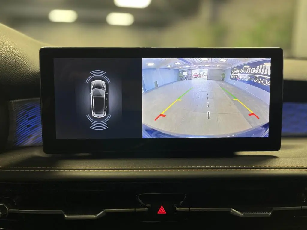 Écran central affichant la caméra de recul et les capteurs de stationnement de l'Alfa Romeo Tonale bleu 2024.