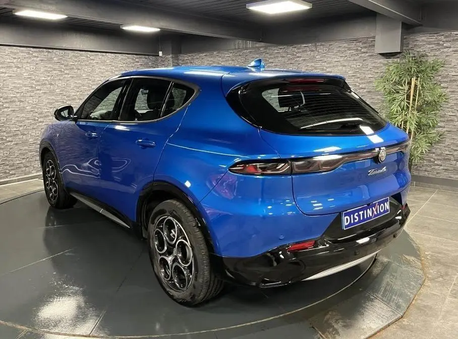 Vue 3/4 arrière droite d'un Alfa Romeo Tonale bleu métallisé avec jantes 18 pouces et antenne aileron de requin.