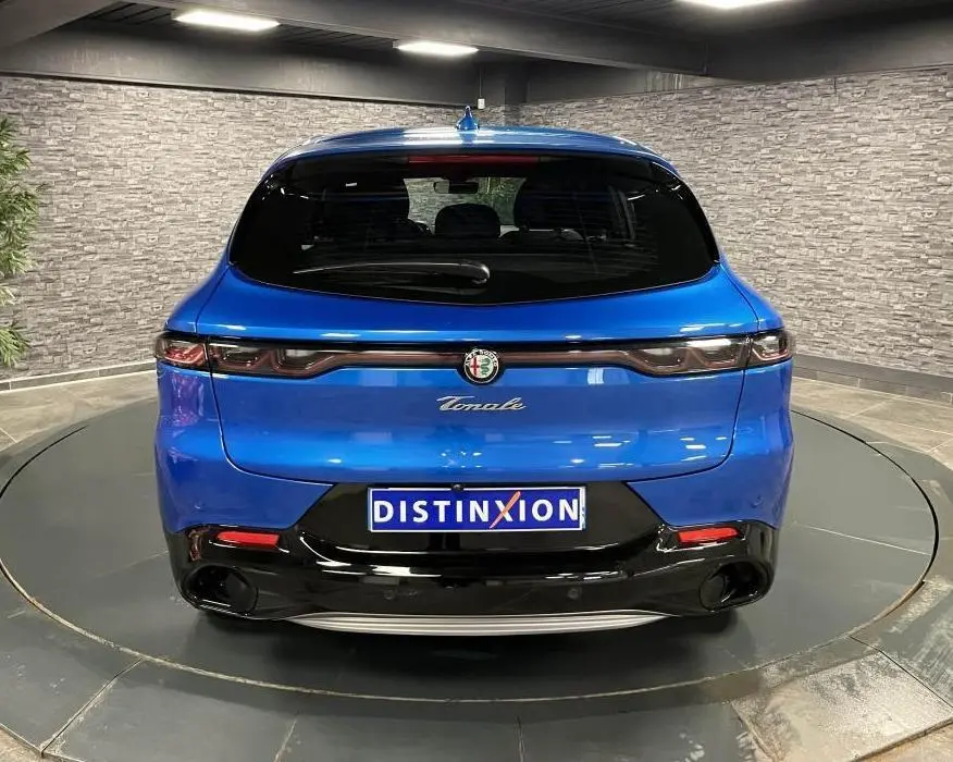 Vue arrière de l'Alfa Romeo Tonale bleu métallisé 2024 avec feux arrière full LED et logo chromé central.