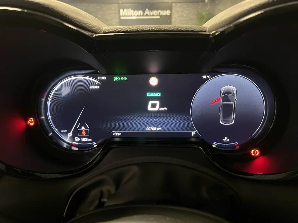 Tableau de bord digital de l'Alfa Romeo Tonale 2024 affichant la vitesse, alertes et mode de conduite DNA.