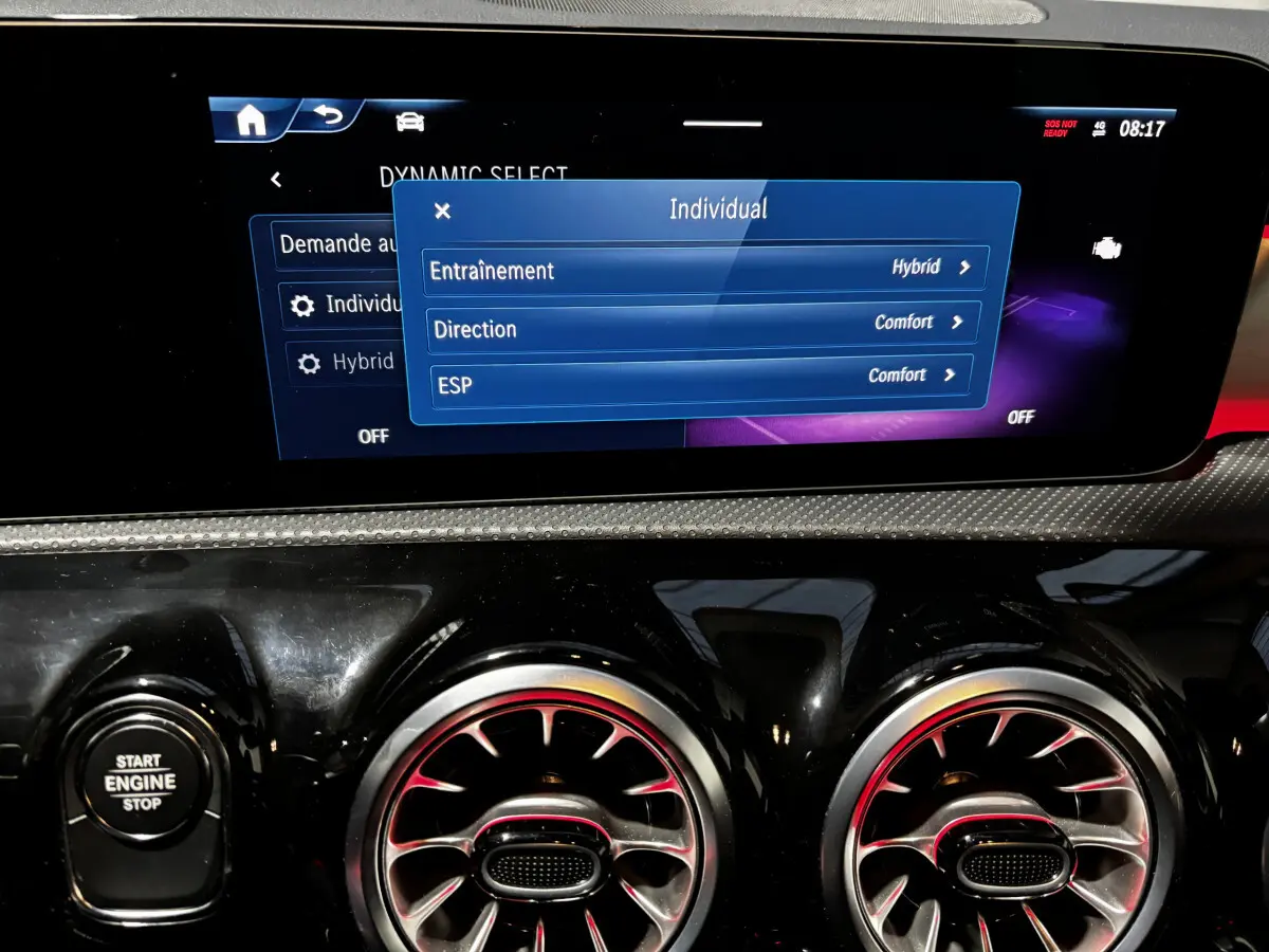 Vue rapprochée du tableau de bord noir de la Mercedes CLA 250 e AMG Line 2023, écran tactile et commandes circulaires d’aération.