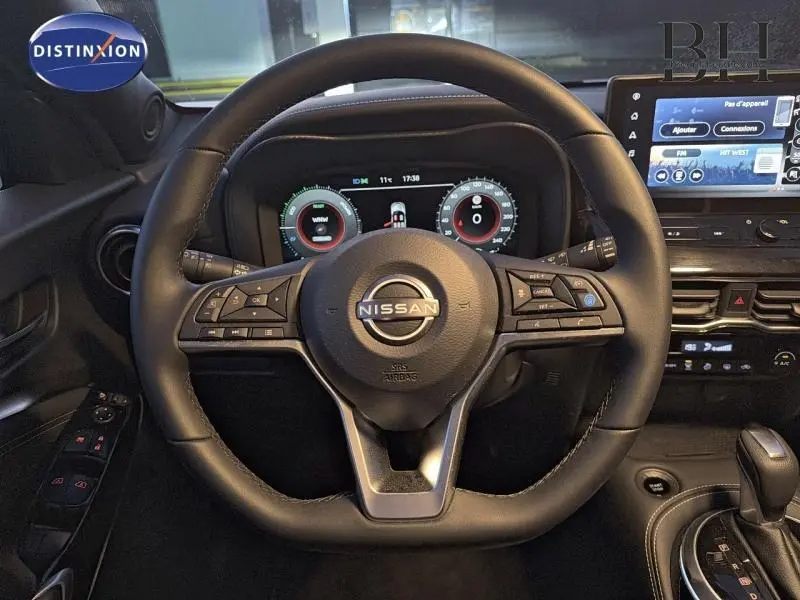 Vue intérieure centrée sur le volant noir du Nissan Juke 1.6 Hybrid 2025 avec tableau de bord numérique et écran tactile.