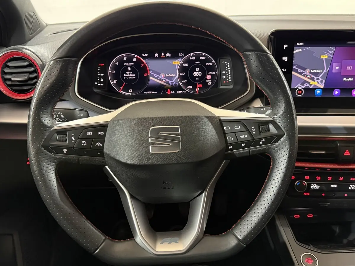 Vue intérieure centrée sur le volant cuir perforé avec logo SEAT et tableau de bord numérique de la Ibiza 1.0 TSI 110 FR.