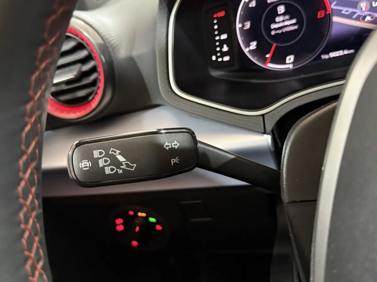 Gros plan sur la manette de clignotants et tableau de bord numérique de la SEAT Ibiza 1.0 TSI 110 FR 2024, intérieur noir.