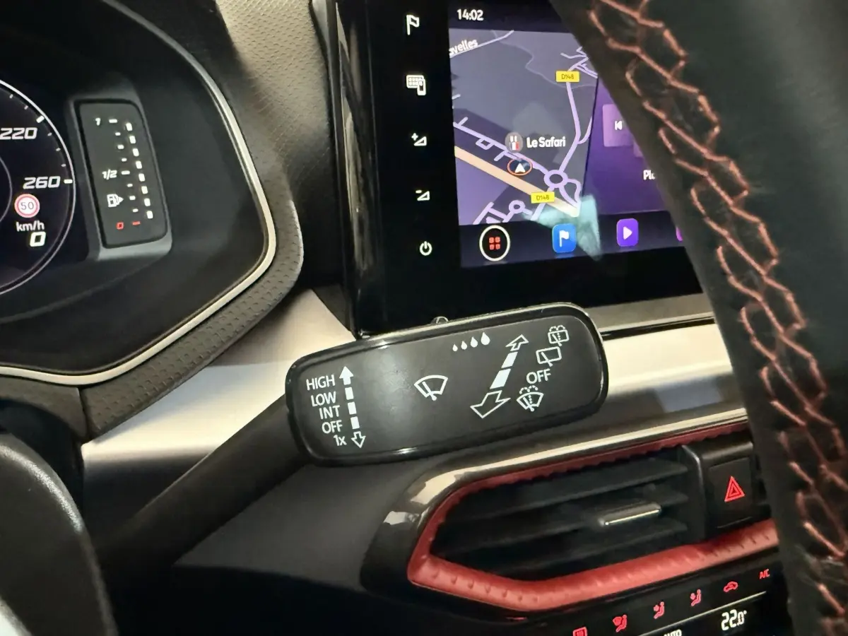 Gros plan sur la commande des essuie-glaces et l’écran tactile de navigation dans l’habitacle de la SEAT Ibiza blanche 2024.