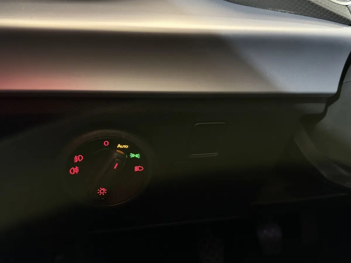 Gros plan sur le bouton de commande des phares du tableau de bord d'une SEAT Ibiza blanche, version 2024.