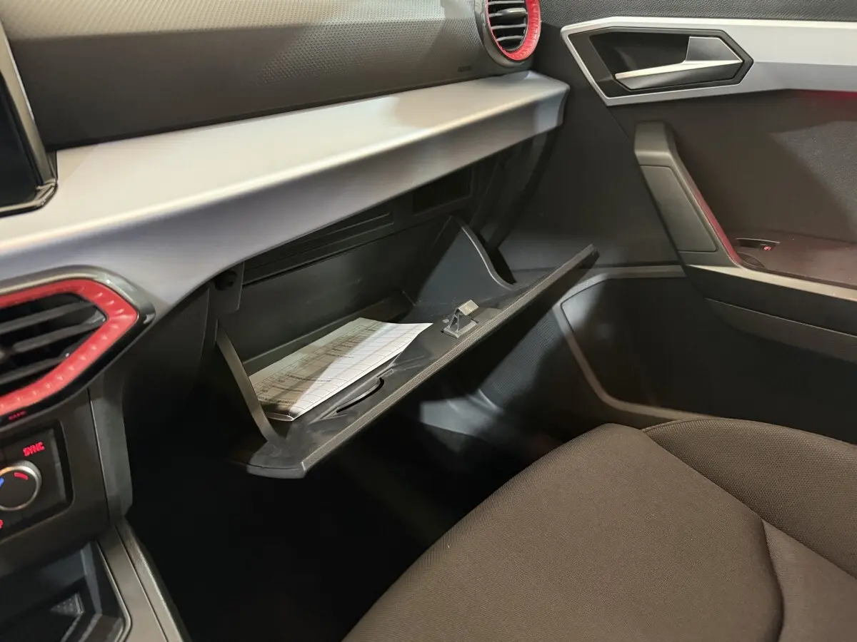 Vue intérieure côté passager du tableau de bord gris et noir avec boîte à gants ouverte de la SEAT Ibiza 1.0 TSI 110 FR blanche 2024.