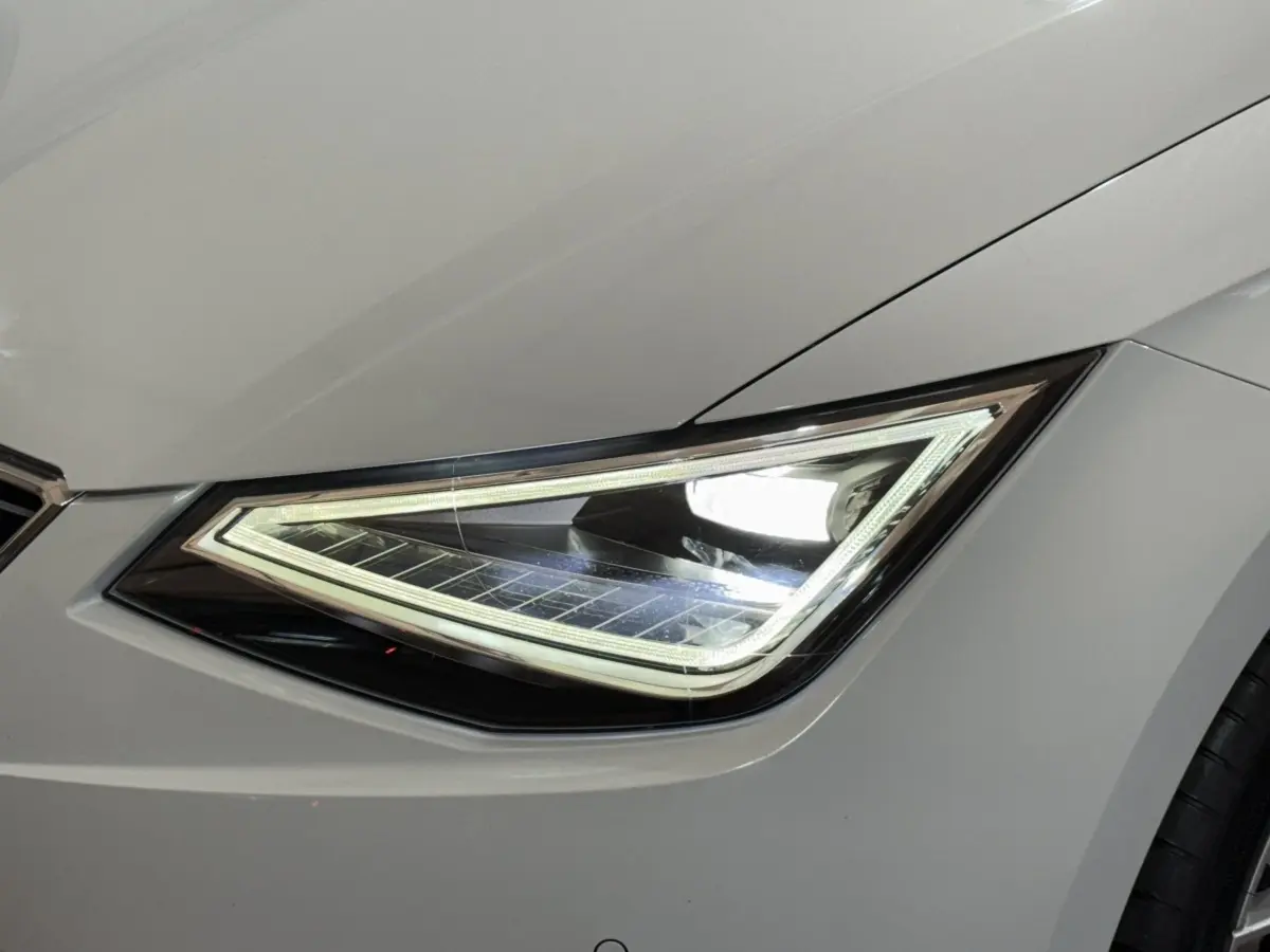 Gros plan sur le phare avant droit LED d'une SEAT Ibiza blanche, soulignant ses lignes anguleuses modernes.