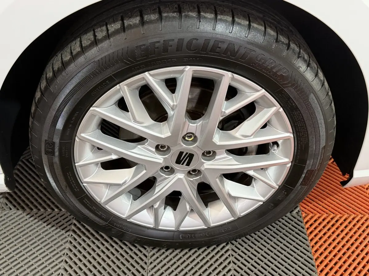 Gros plan sur la roue avant droite de la SEAT Ibiza blanche, mettant en valeur la jante alliage argentée au design moderne.