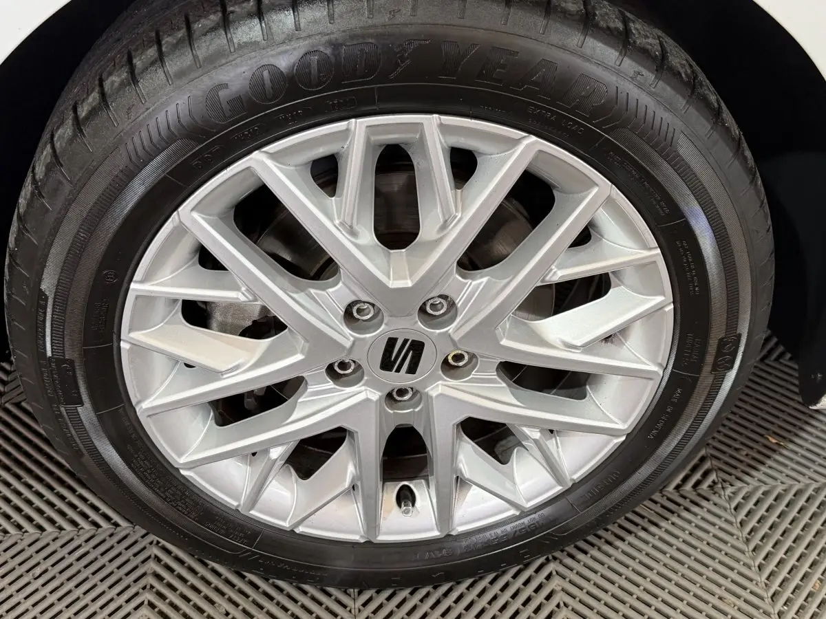 Gros plan sur la jante alliage argentée et pneu Goodyear d’une SEAT Ibiza blanche, vue côté roue arrière.