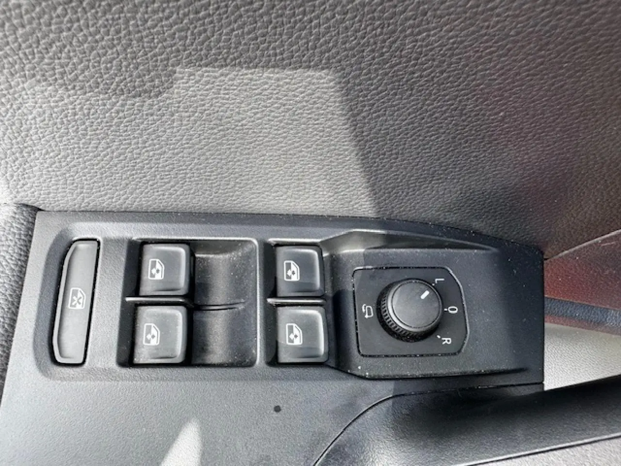 Panneau de commandes des vitres et rétroviseurs côté conducteur d'une SEAT Arona 2024 avec intérieur noir texturé.
