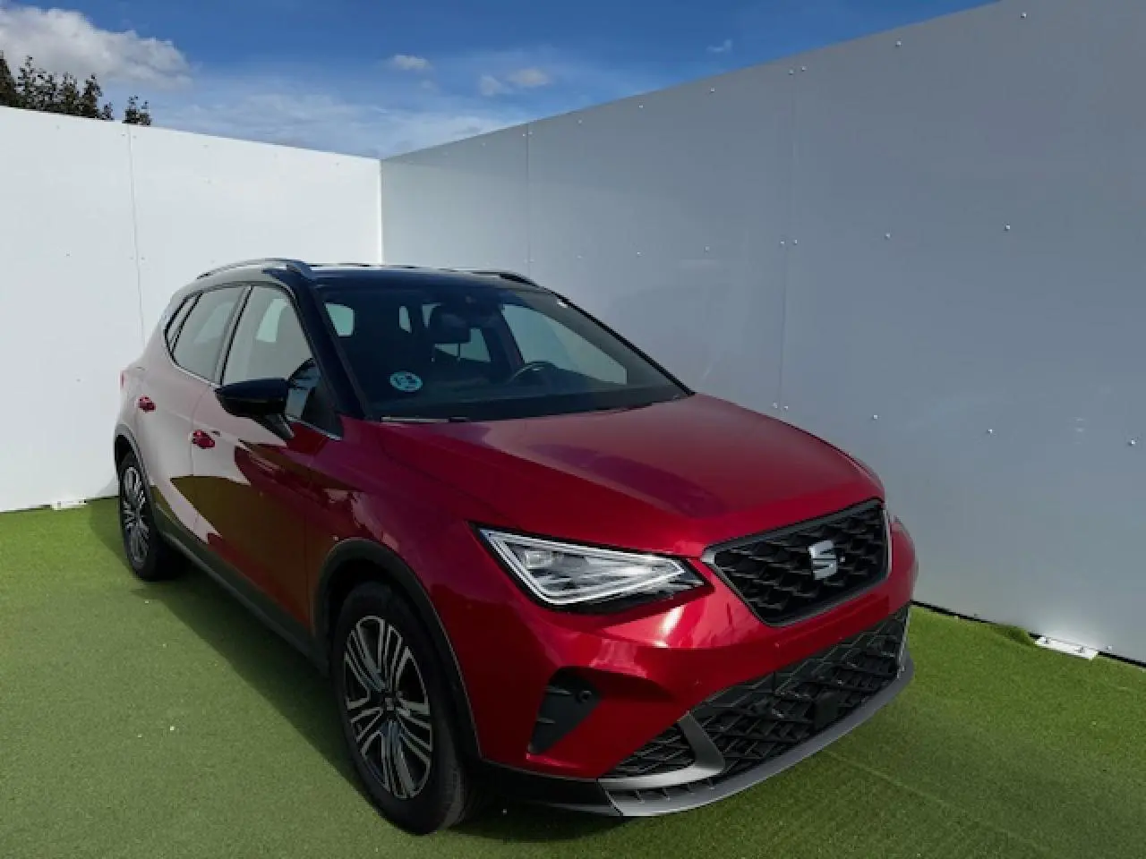 SEAT Arona rouge Désir avec toit noir, vue 3/4 avant droit, calandre FR et jantes alliage 17 pouces.