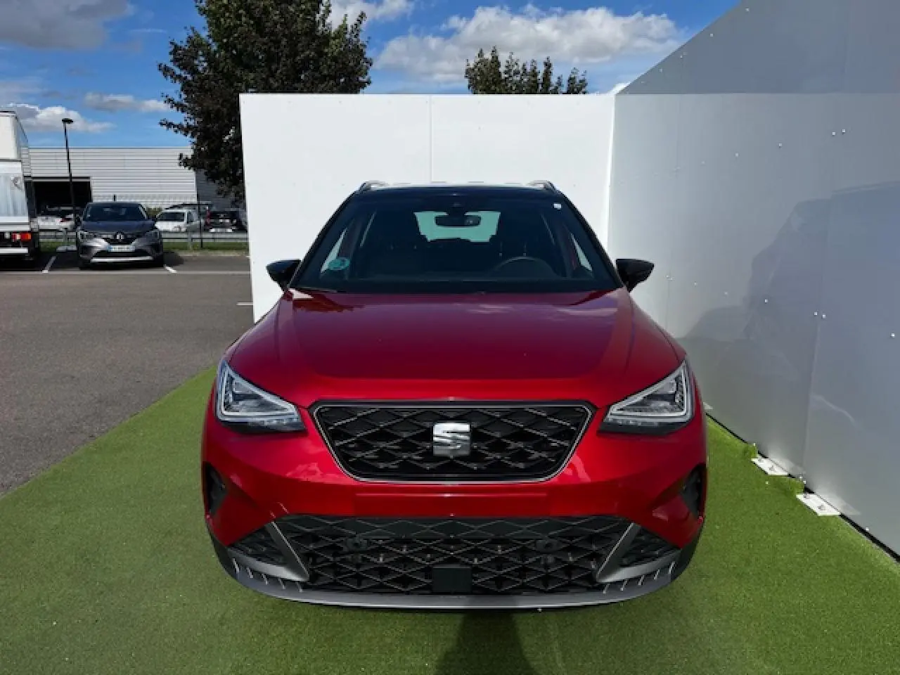Vue de face d'un SEAT Arona 2024 rouge Désir avec toit noir et calandre spécifique FR gris cosmique.