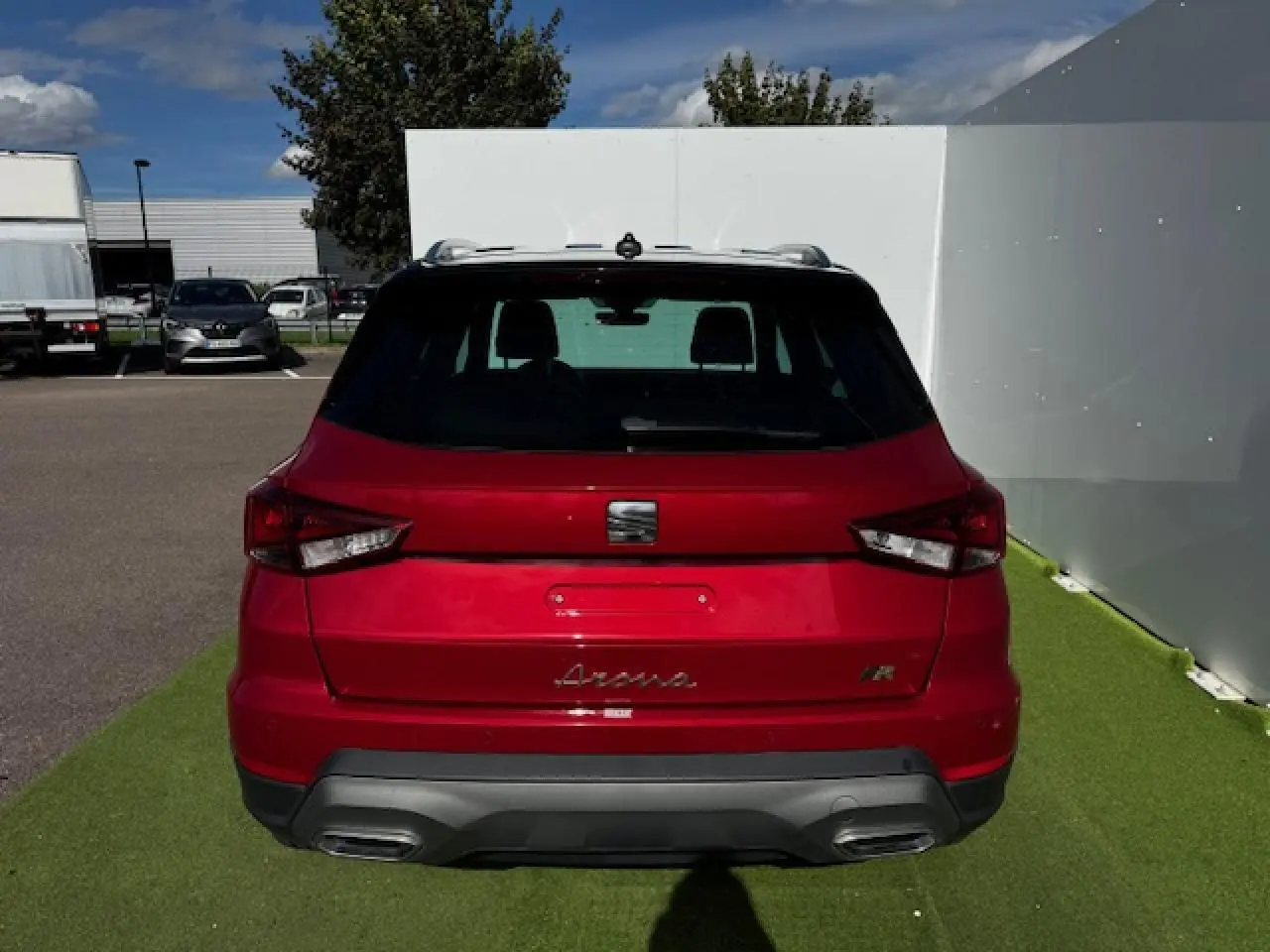 Vue arrière d'un SEAT Arona rouge Désir avec toit noir et double sortie d'échappement intégrée au diffuseur gris.