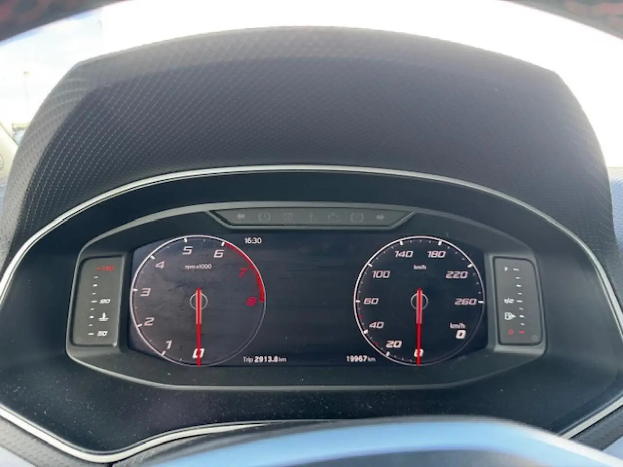 Vue rapprochée du tableau de bord numérique du SEAT Arona 2024, affichant compte-tours et vitesse à l'arrêt.