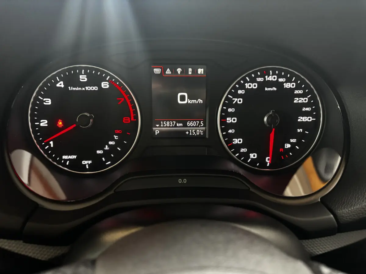 Vue rapprochée du combiné d'instruments noir de l'Audi Q2 35 TFSI 2023, affichant 0 km/h et 15°C.