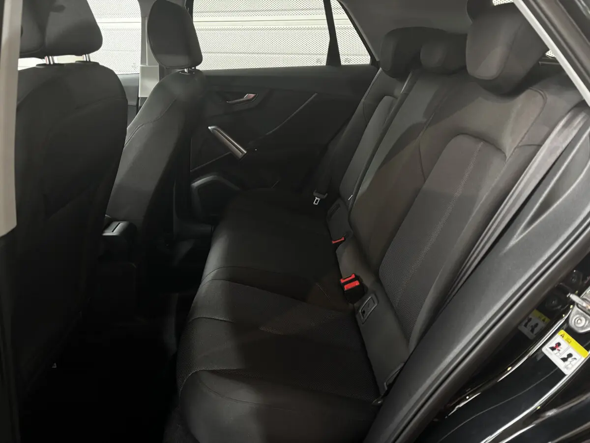 Vue intérieure côté droit des sièges arrière noirs de l'Audi Q2 35 TFSI S Line 2023 avec habillage tissu.