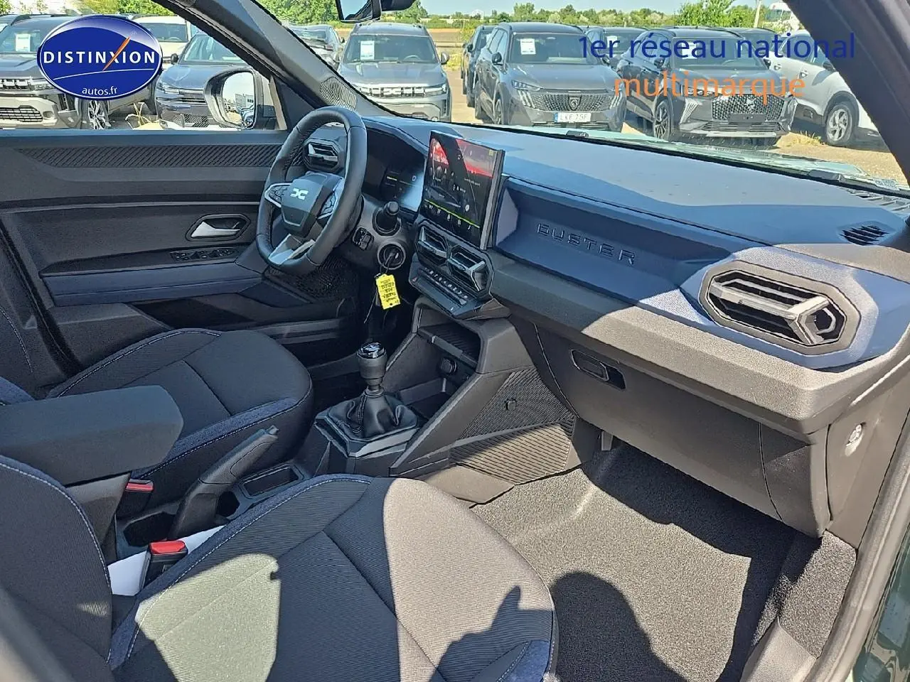 Vue intérieure côté conducteur du Dacia Duster 2025 avec tableau de bord moderne et volant multifonction.