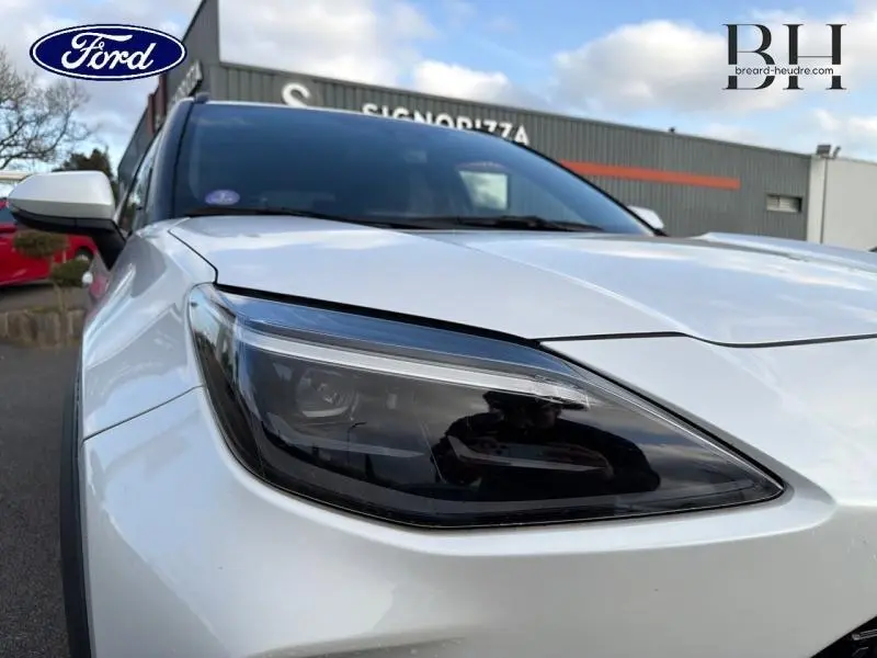 Gros plan sur le phare avant droit du Toyota Yaris Cross blanc lunaire nacré, soulignant son design moderne et précis.