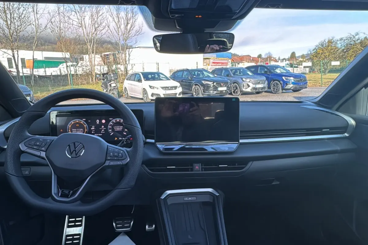 Vue intérieure avant du Volkswagen T-Roc noir ebène 2026, tableau de bord numérique et écran tactile central.